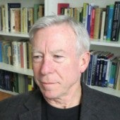 a headshot of Steve Crowell with a slight smile, and a bookshelf in the background