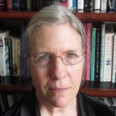a simple headshot-style picture of Claire Fanger, with bookshelf in the background