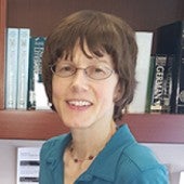 a simple picture of Hilary Mackie, with a bookshelf in the background