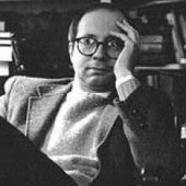 a casual black and white photo of Stroup, his hand to his face and looking pensive